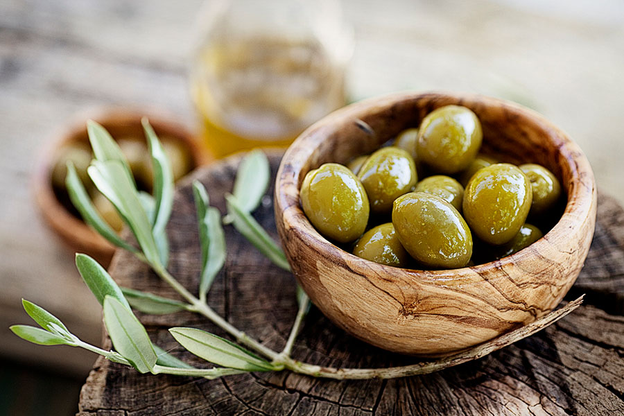 green olives in a olive wood bowl