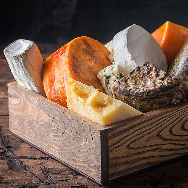 different types of cheese in a wood box